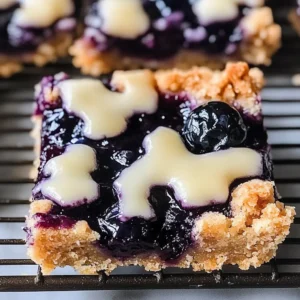 Delicious blueberry pie bars served on a plate with fresh blueberries